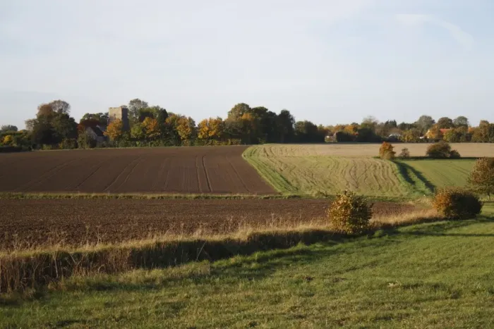 Framed Print : View of arable farmland with cultivated and fallow fields, church amongst trees in distance, St Framed Print : View of arable farmland with cultivated and fallow fields, church amongst trees in distance, St
