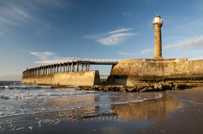 Framed Print : View of beach and pier with 19th century stone lighthouse in evening sunlight, East Pier, Whitby, North Yorkshire Framed Print : View of beach and pier with 19th century stone lighthouse in evening sunlight, East Pier, Whitby, North Yorkshire