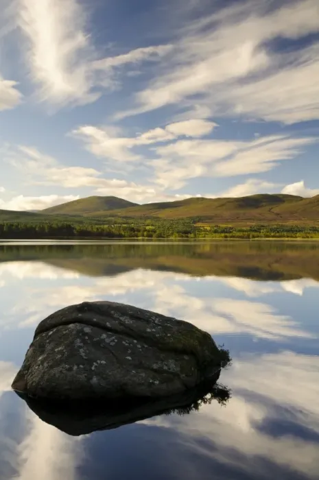 Framed Print : View of blue sky, clouds and rock reflected in still water of freshwater loch, Loch Garten, Abernethy Forest