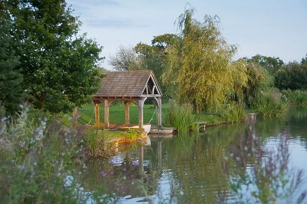 View of boathouse on fishing pond at sunset, Little Budworth, Tarporley, Cheshire, England, september