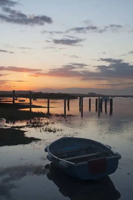 Framed Print : View of boats in coastal creek at high tide, silhouetted at sunset, Burnham Deepdale, Norfolk, England, march