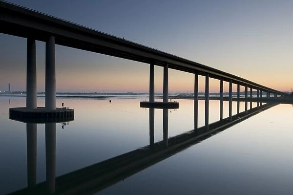 View of bridge reflected in estuary at dawn, Sheppey Crossing, The Swale Estuary, Isle of Sheppey, Kent, England, July