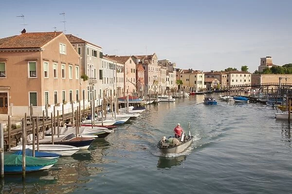 View of canal with fisherman in boat, Canale di San Petro, Castello District, Venice, Veneto, Italy, May