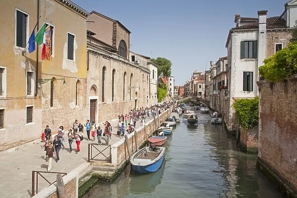 View of canal and tourists walking on canalside street, Fondamenta Santa Caterina, Canareggio District, Venice, Veneto