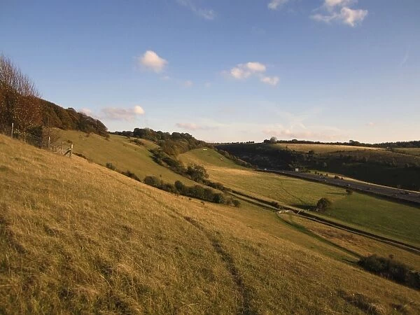 View of chalk grassland on hillside and distant M40 Motorway, Aston Rowant N. N. R