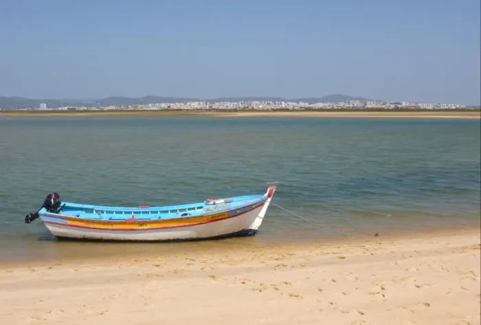 Framed Print : View of city from coastal island with fishing boat, Figo, Algarve, Portugal, april Framed Print : View of city from coastal island with fishing boat, Figo, Algarve, Portugal, april