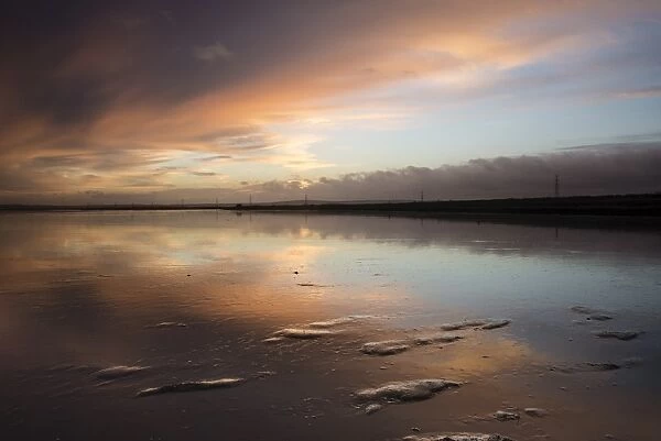 View of clouds reflected in mud at sunrise, Oare Creek, Oare, Faversham, North Kent, England, January