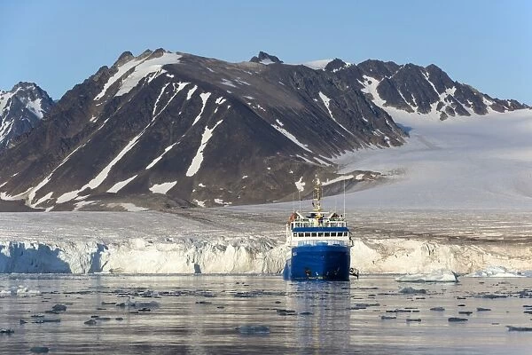 View of coastal glacier terminus and mountains with MS Quest icebreaker cruise ship, Lilliehookbreen, Spitsbergen