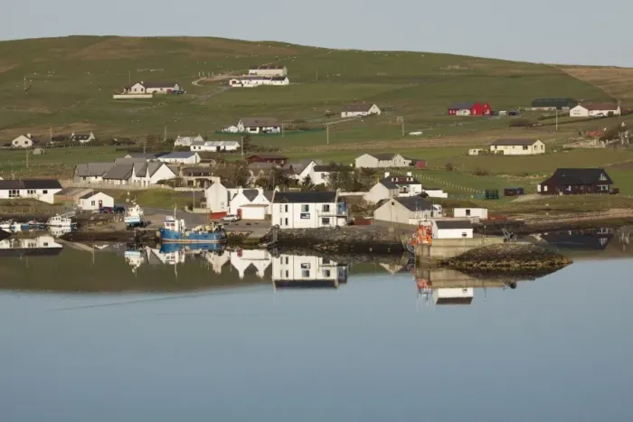 Framed Print : View of coastal village reflected in sea, Aith, Aith Voe, Mainland, Shetland Islands, Scotland, May