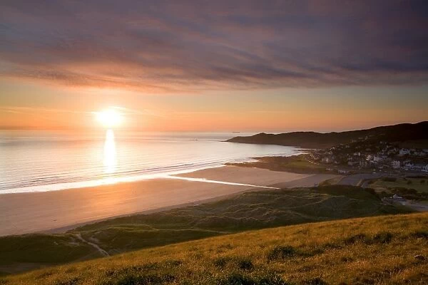View of coastline and seaside resort at sunset, viewed from Potters Hill, Woolacombe Beach, North Devon, England, june