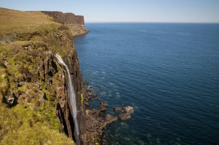 Framed Print : View of coastline with waterfall tumbling over cliffs into sea, with Kilt Rock in background, Mealt Falls