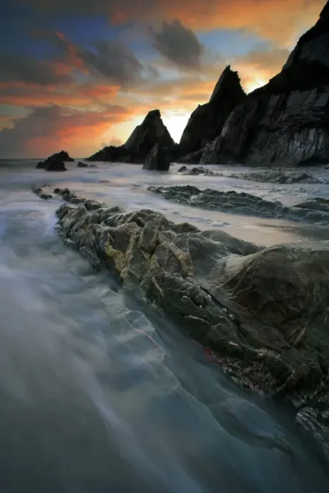 Framed Print : View of eroded rock formations on beach in sandy cove at sunset, Westcombe Beach, near Bigbury, Devon, England Framed Print : View of eroded rock formations on beach in sandy cove at sunset, Westcombe Beach, near Bigbury, Devon, England