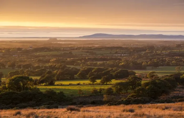 Framed Print : View of farmland on coastal plain at sunset, looking towards Morecambe Bay with Lake District fells in background Framed Print : View of farmland on coastal plain at sunset, looking towards Morecambe Bay with Lake District fells in background