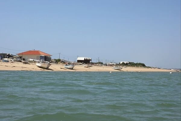 View of fishing village with fishermens houses on landward side of coastal spit, Ria Formosa N. P