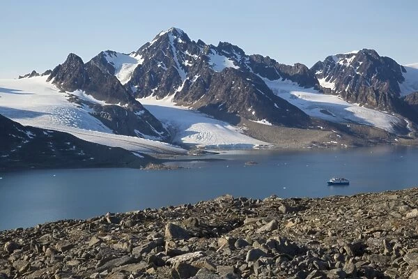 View of fjord coastline with mountains, glacier and MS Quest icebreaker cruise ship, Raudfjorden, Spitsbergen