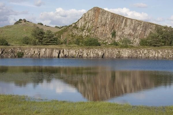 View of flooded former whinstone quarry with exposed rockface, Cawfields Quarry, Hadrians Wall, Northumberland N. P