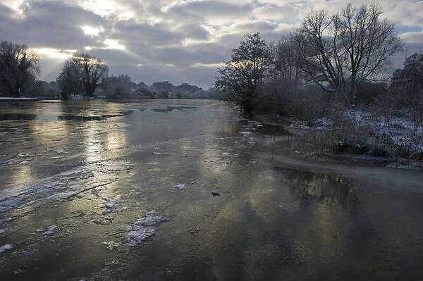 View of frozen river, Ferry Lane Wood, River Yare, The Broads, near Postwick, Norfolk, England, december