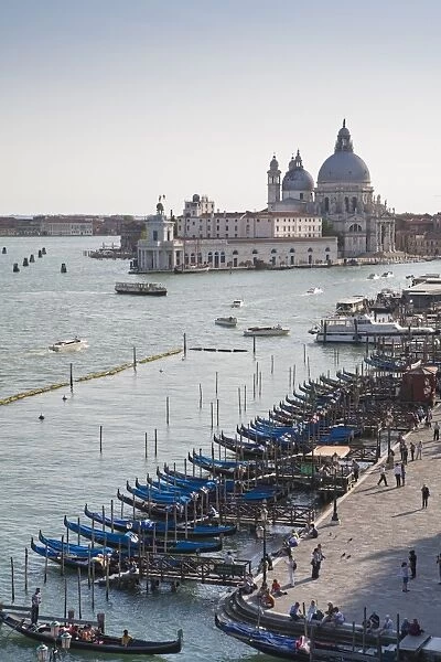 View of gondolas moored along waterfront with Roman Catholic church in background, Santa Maria della Salute