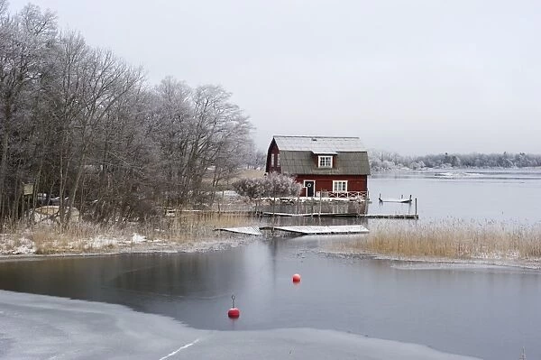 View of house and frozen lake, Fogdo, Lake Malaren, Sodermanland, Baltic Sea, Sweden, january