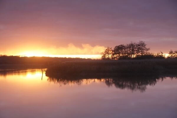 View of lake at sunset, Far Ings National Nature Reserve, Barton Upon Humber, Lincolnshire, England, December