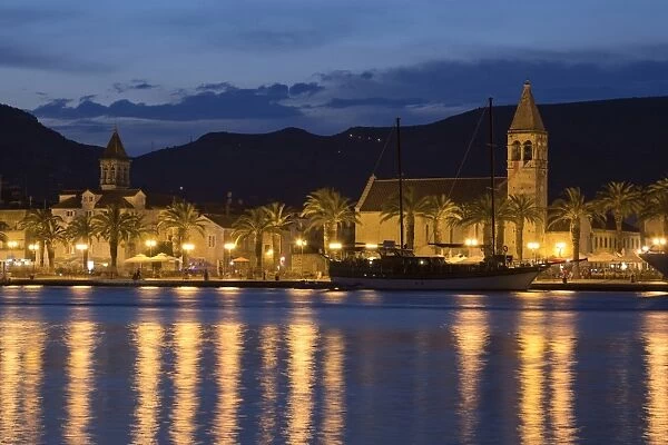 View of old town and harbour with Catholic church and palm trees at night, Trogir, Dalmatia, Croatia, July