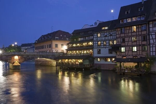 View of old town with timber-framed buildings, bridge and canal at night, Strasbourg, Alsace, France, july