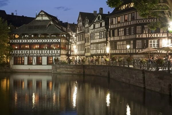 View of old town with timber-framed buildings and canal at night, Strasbourg, Alsace, France, july