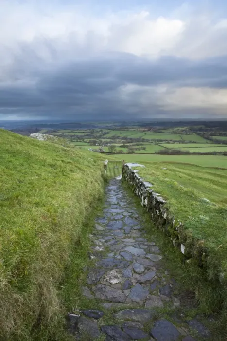 Framed Print : View of path and gate leading from 13th century church on moorland at sunrise