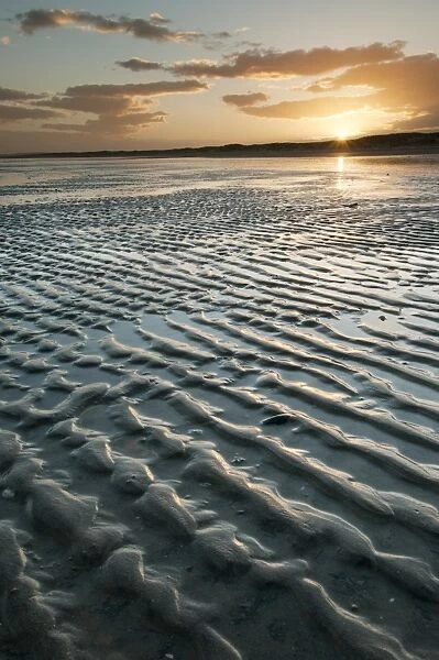 View of ripples in sand on beach during low tide at sunset, Camber Sands, East Sussex, England, June