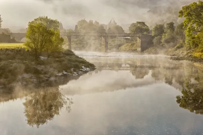 Framed Print : View of river, bridge and Cistercian abbey ruins in mist at dawn, Tintern Abbey, Tintern, River Wye, Wye Valley