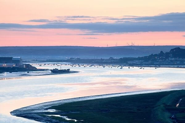View of river estuary with shipyard, village and distant windfarm on banks at sunrise, Fullabrook Windfarm