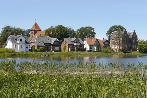 View across river towards historic town, Ribe, Jutland, Denmark, may