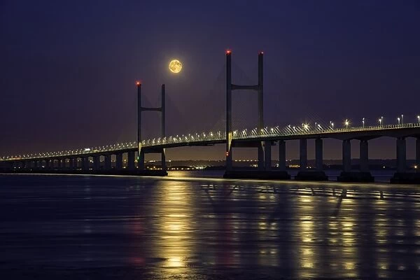 View of road bridge over river at twilight with full moon, viewed from Divers Rock at Sudbrook, Second Severn Crossing