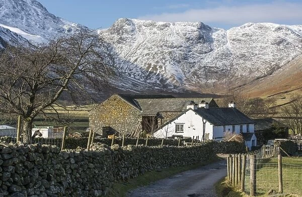 View of road, drystone wall and farm buildings, with snow covered fell in background, Langdale Fell, Great Langdale