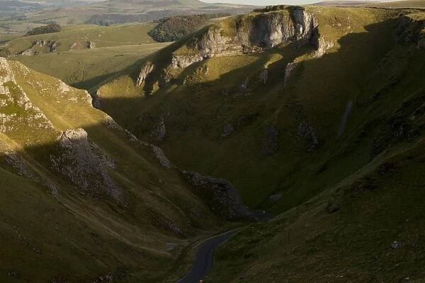 View of road through moorland with limestone pinnacles in shadow, Winnats Pass, Hope Valley, Peak District, Derbyshire