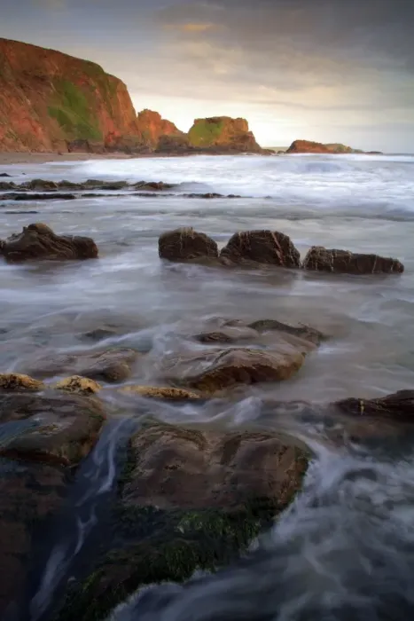 Framed Print : View of rocks on beach in cove at sunset, Westcombe Beach, Devon, England Framed Print : View of rocks on beach in cove at sunset, Westcombe Beach, Devon, England