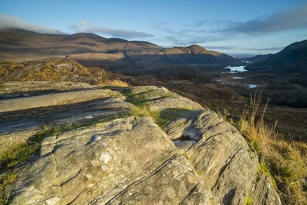 View over rocks on moorland towards lake and mountains at dawn, Ladies View, Lough Leane (Lower Lake)