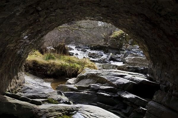 View of rocky river through bridge arch, River Feshie, Feshiebridge, Cairngorms N. P