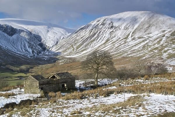 View of ruined stone barn and upland farmland in snow, looking from Bluecaster Fell into Cautley Crag