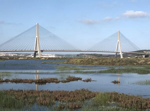 View across saltpans towards bridge at border with Spain, Castro Marim Marshes Reserve, Algarve, Portugal, march