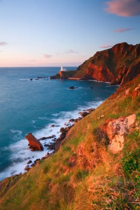 Framed Print : View of sea cliffs with distant lighthouse at sunset, with wreck of MV Johanna in foreground, Hartland Lighthouse Framed Print : View of sea cliffs with distant lighthouse at sunset, with wreck of MV Johanna in foreground, Hartland Lighthouse