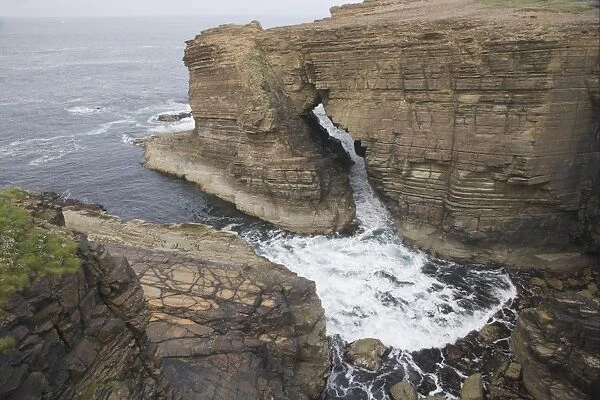 View of sea cliffs with water flowing through sea arch, Yesnaby, Mainland, Orkney, Scotland, june