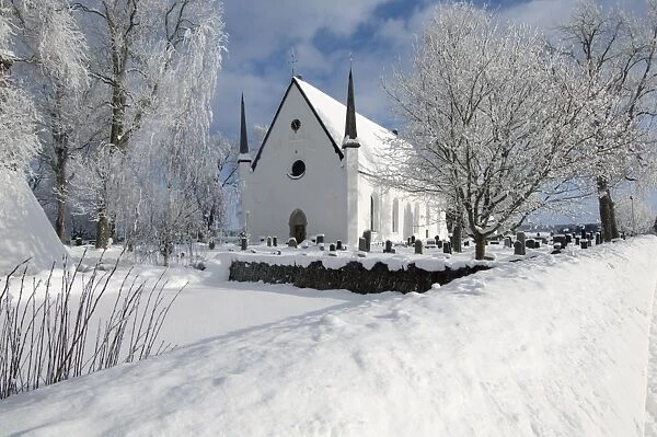 View of snow covered church and graveyard, Tierp, Uppsala County, Uppland, Sweden, february