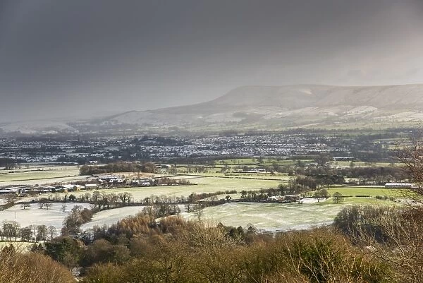 View across snow covered farmland, looking towards Clitheroe from Longridge Fell, Forest of Bowland, Lancashire