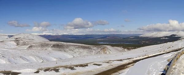 View across snow covered mountain, looking towards Loch Morlich with Aviemore and Monadhliath Mountains in distance