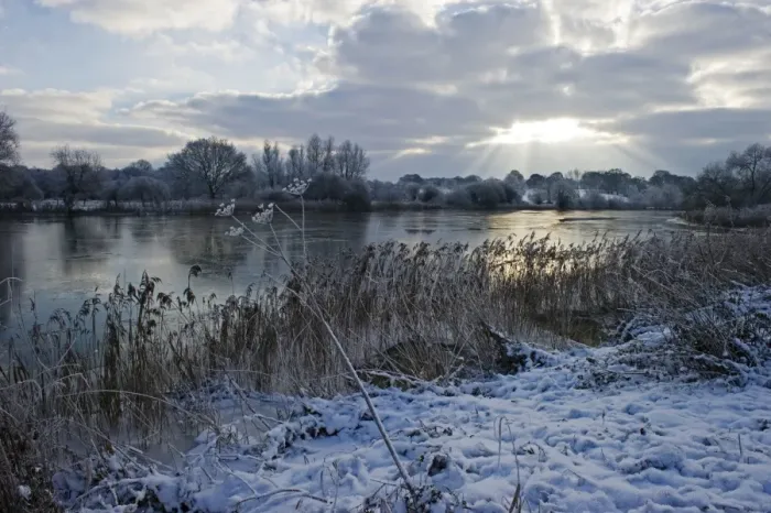Framed Print : View of snow covered riverbank and frozen river, Ferry Lane Wood, River Yare, The Broads, near Postwick, Norfolk