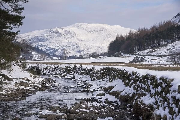 View of stream flowing through snow covered upland landscape, Grisedale Beck, Grisedale, Lake District, Cumbria
