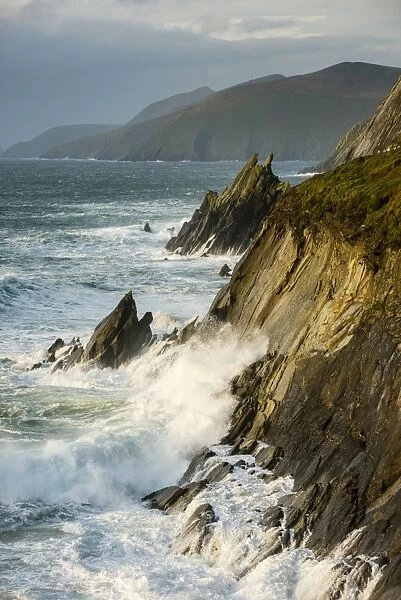 View of swell waves breaking and crashing against cliff at dawn, Coumeenole North, Dingle Peninsula, County Kerry