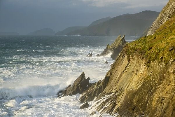 View of swell waves breaking and crashing against cliff at dawn, Coumeenole North, Dingle Peninsula, County Kerry