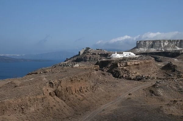 View of volcanic coastal landscape with white-washed Orthodox church, Balos Bay, Santorini, Cyclades, Aegean Sea